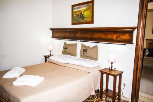 a bedroom with a large bed with a wooden headboard at Casa Vacanze Antico Poggio in Poggio San Giovanni