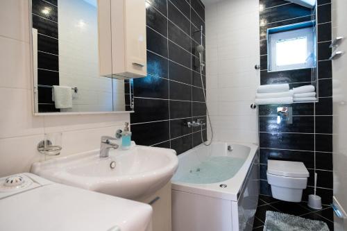 ein Badezimmer mit Waschbecken, Toilette und Badewanne in der Unterkunft City Apartments Premium in Trebinje