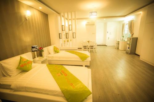 um quarto de hotel com duas camas e uma sala de estar em New Hotel & Apartment em Thu Dau Mot