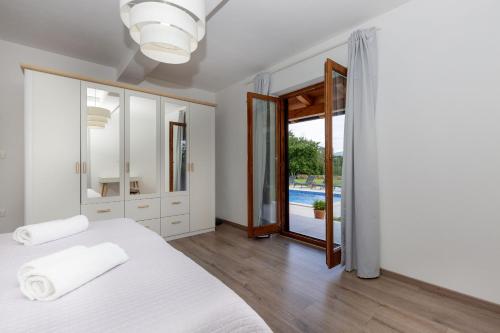 a white bedroom with a bed and a mirror at Villa Flora in Kršan