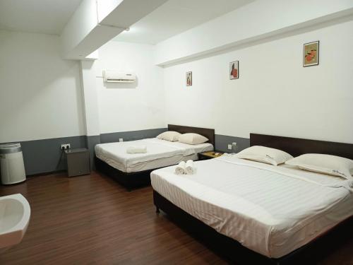 a room with two beds and a sink in it at SO Hotel in George Town