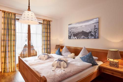 a bedroom with a bed with stuffed animals on it at Landhaus Kränzle in Fischen