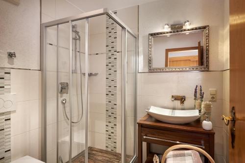a bathroom with a glass shower and a sink at Landhaus Kränzle in Fischen