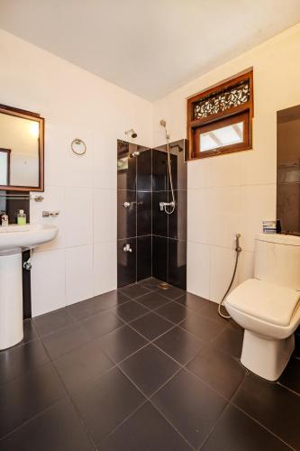 a bathroom with a toilet and a shower and a sink at Uyanawatta villa talpe in Talpe