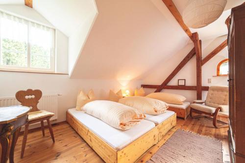 a attic bedroom with two beds and a table at Körnermühle in Dippoldiswalde