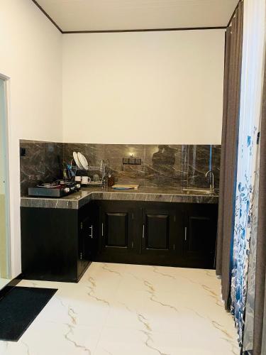 a kitchen with a sink and a counter top at Abi Restaurant & Villa in Tangalle