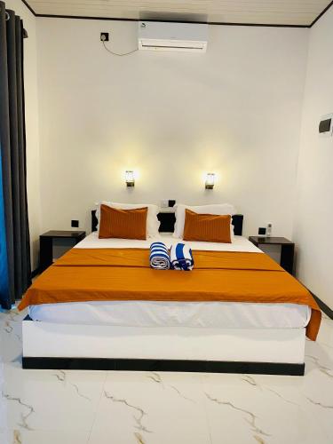 a bedroom with a large bed with two towels on it at Abi Restaurant & Villa in Tangalle