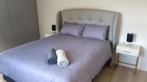 a bedroom with a bed with two towels on it at Simons Town long beach Penthouse in Simonʼs Town