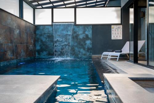 a swimming pool with a water feature in a building at Naomi Boutique Suites in Netu'a