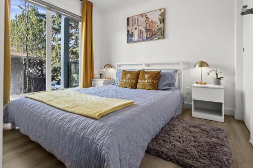 a bedroom with a bed and a large window at GlobalStay Cozy 1 Bedroom Condo with Balcony Downtown Calgary in Calgary