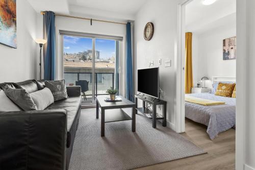 a living room with a couch and a bed and a television at GlobalStay Cozy 1 Bedroom Condo with Balcony Downtown Calgary in Calgary