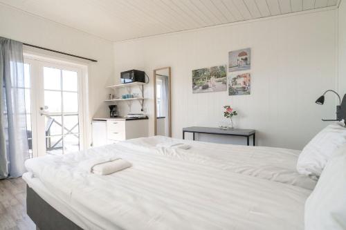 a large white bed in a room with a window at Visby Strandby in Visby
