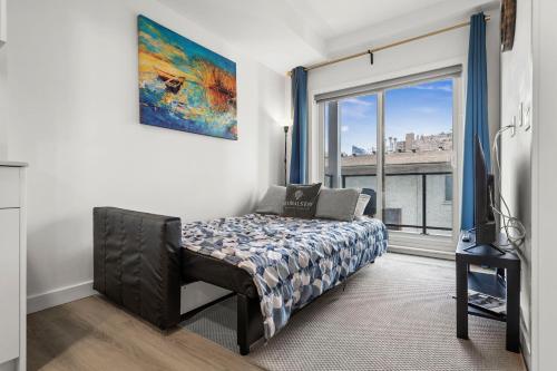 a bedroom with a bed and a large window at GlobalStay Cozy 1 Bedroom Condo with Balcony Downtown Calgary in Calgary