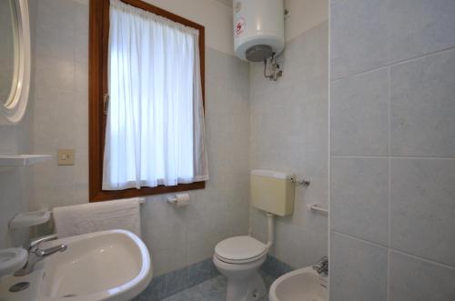 un bagno bianco con un water e un lavandino di Ville Carla e Caterina a Bibione