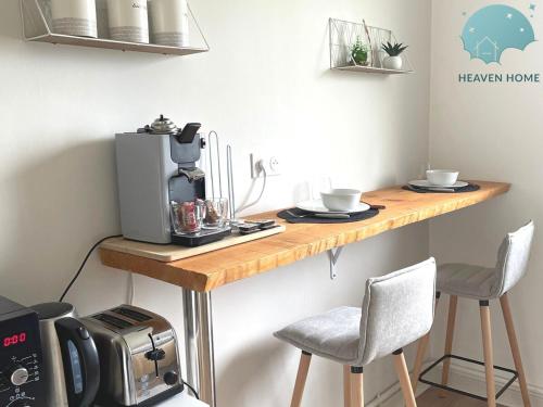 eine Küchentheke mit Kaffeemaschine und 2 Stühlen in der Unterkunft Agreable T2 proche des commerces et gare in Saint-Brieuc