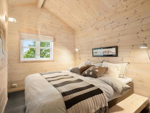 a bedroom with a bed in a wooden wall at Family Cabin With Hot Tub In Hønedalen in Haugen
