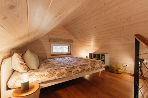 una cama en una habitación con techo de madera en Tiny Vacation, en Písek