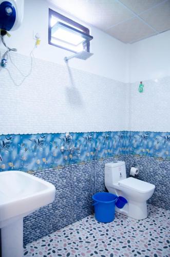 a bathroom with a white sink and a toilet at Nt Riverside Homestay in Dirang Dzong