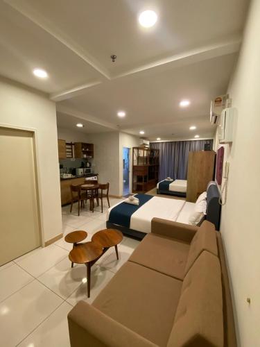 a bedroom with a couch and a bed and a table at Timurbay Seafront Residence in Kuantan