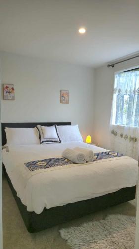 a large bed in a bedroom with a window at Amie's Charming Villa in Tauranga