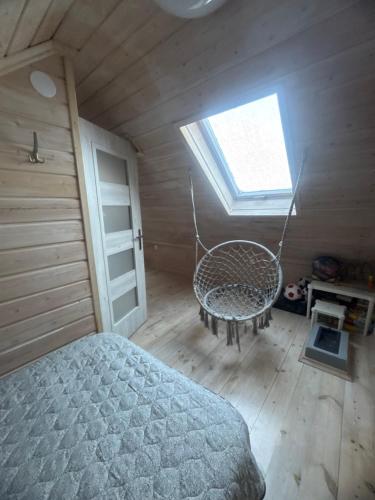 斯特日察Domek Helenka的一间卧室配有床、窗户和秋千