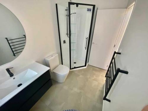 a bathroom with a shower and a toilet and a sink at Amie's Charming Villa in Tauranga