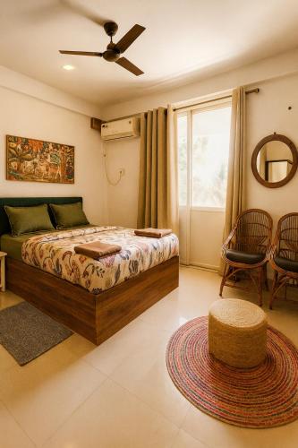 a bedroom with a bed and a table and chairs at Hotel Amore Mio Morjim - Beachfront Hotel on Morjim Beach in Morjim