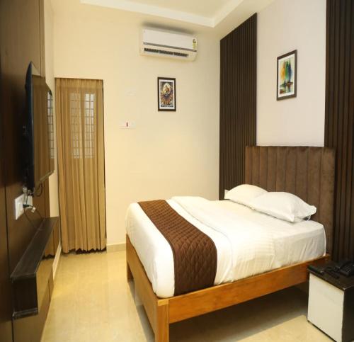 ein Schlafzimmer mit einem großen Bett und einem Fernseher in der Unterkunft SK Home Stay in Mayiladuthurai