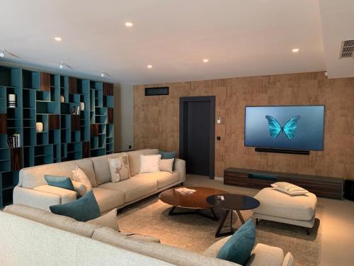 un soggiorno con un divano e una TV con una farfalla sullo schermo di Villa Arizona a Port Grimaud