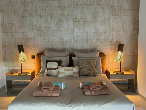un grande letto con due lampade e asciugamani sopra di Villa Arizona a Port Grimaud
