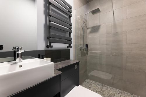 a bathroom with a white sink and a shower at Apartment Stays in Newcastle upon Tyne