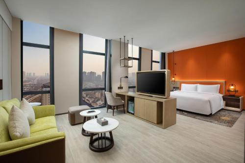 a hotel room with a bed and a tv at Wyndham Handan Congtai in Handan