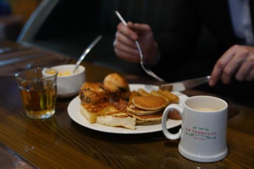 een bord met pannenkoeken en een kop koffie bij Walk-Inn Centaurus Hotel Apartments Islamabad in Islamabad