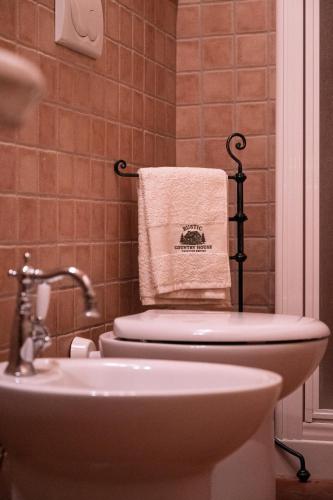 a bathroom with a toilet and a sink and a towel at Rustic Country House in Smirra