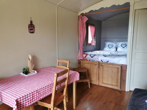 梅内尔伯La Carriole dans le jardin的一间设有桌子和一张带镜子的床的房间