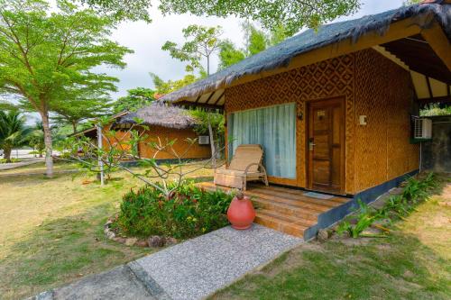 a small house with a wooden porch and a patio at Bintan Exotica Resort By WH - Free Breakfast in Berakit