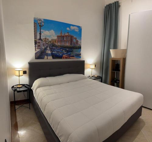 a bedroom with a bed with a painting on the wall at Graziano's House Case Vacanze in Bari