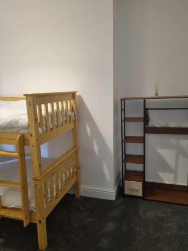 a bedroom with two bunk beds and a book shelf at St Hilary Central Apartment in Llandudno
