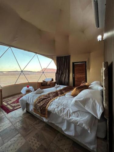 un letto grande in una stanza con una grande finestra di Wadi Rum beautiful time a Wadi Rum