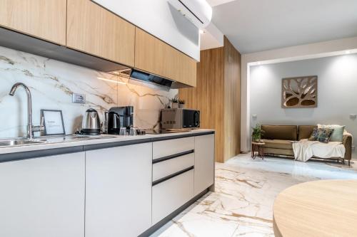 a kitchen with white cabinets and a couch in a living room at Ugo Bassi Apartments in Bologna