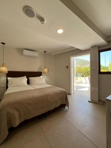 a bedroom with a large bed and a sliding glass door at מלון המושבה כפר תבור in Kefar Tavor