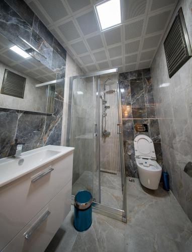 a bathroom with a shower and a toilet and a sink at Zirvesta Otel in Istanbul