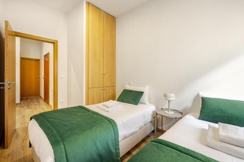 a bedroom with two beds with green and white sheets at Two 2 Two Urban Stay in Vila Real