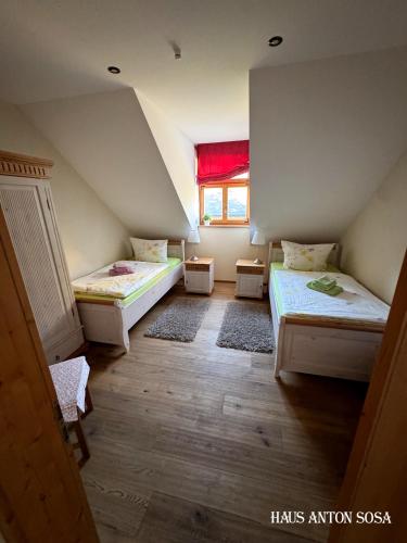 a attic room with two beds and a window at Ferienhaus Anton in Eibenstock