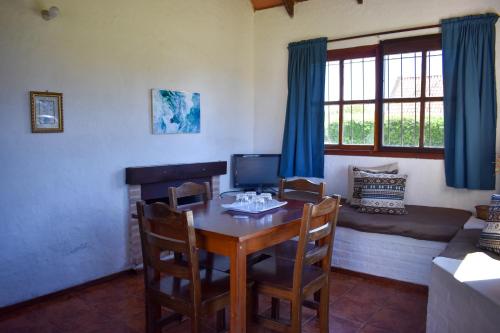 a dining room with a table and chairs and a couch at Country del Sol Complejo Turistico in La Paloma