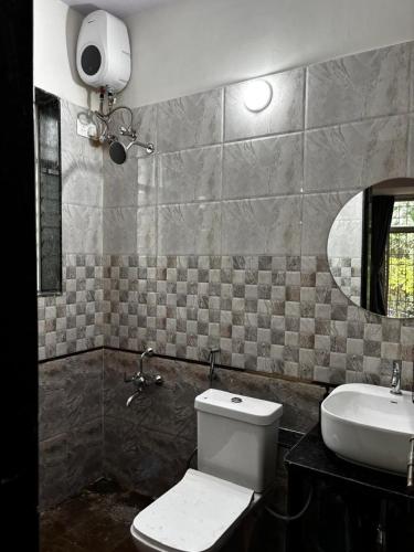 a bathroom with a toilet and a sink at HEMGIRI - Private Pool Villa Mulshi in Mulshi