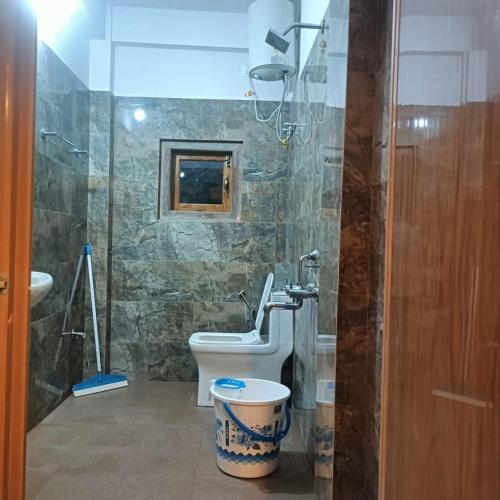 Un baño con inodoro, lavabo y ducha. en SL Guest House, en Mawlynnong