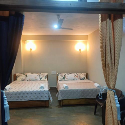 una habitación con dos camas en una habitación en SL Guest House, en Mawlynnong