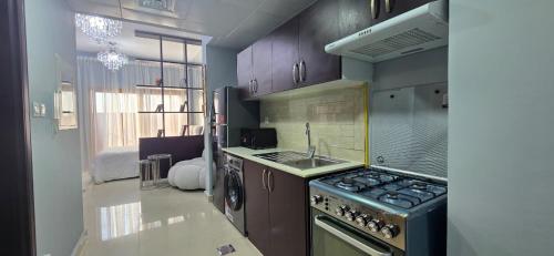 a kitchen with a stove and a sink at Peaceful Apartments in Dubai