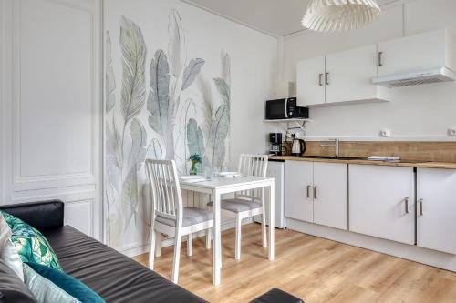 eine Küche mit Tisch und Stühlen in einem Zimmer in der Unterkunft Blue Bird charmant studio avec place de parking ! in Rouen